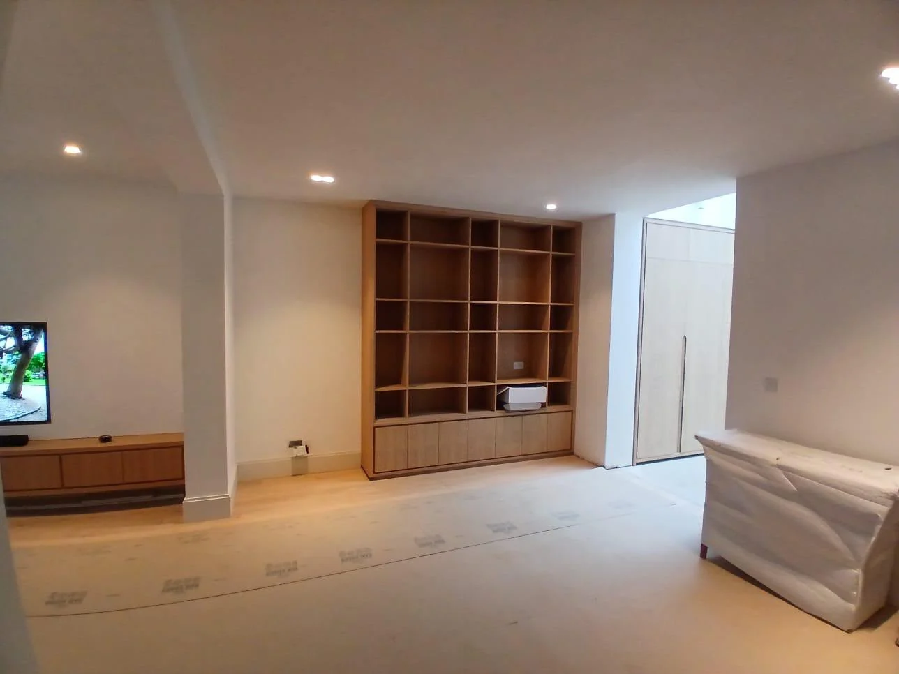 Living room with bespoke oak shelving and a fitted media unit